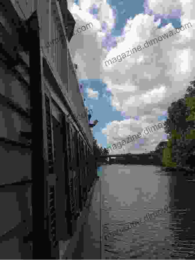 A Tranquil Canal Boat Gliding Through The Serenity Of A Secluded River, Surrounded By Lush Greenery. Narrowboat Life: Discover Life Afloat On The Inland Waterways